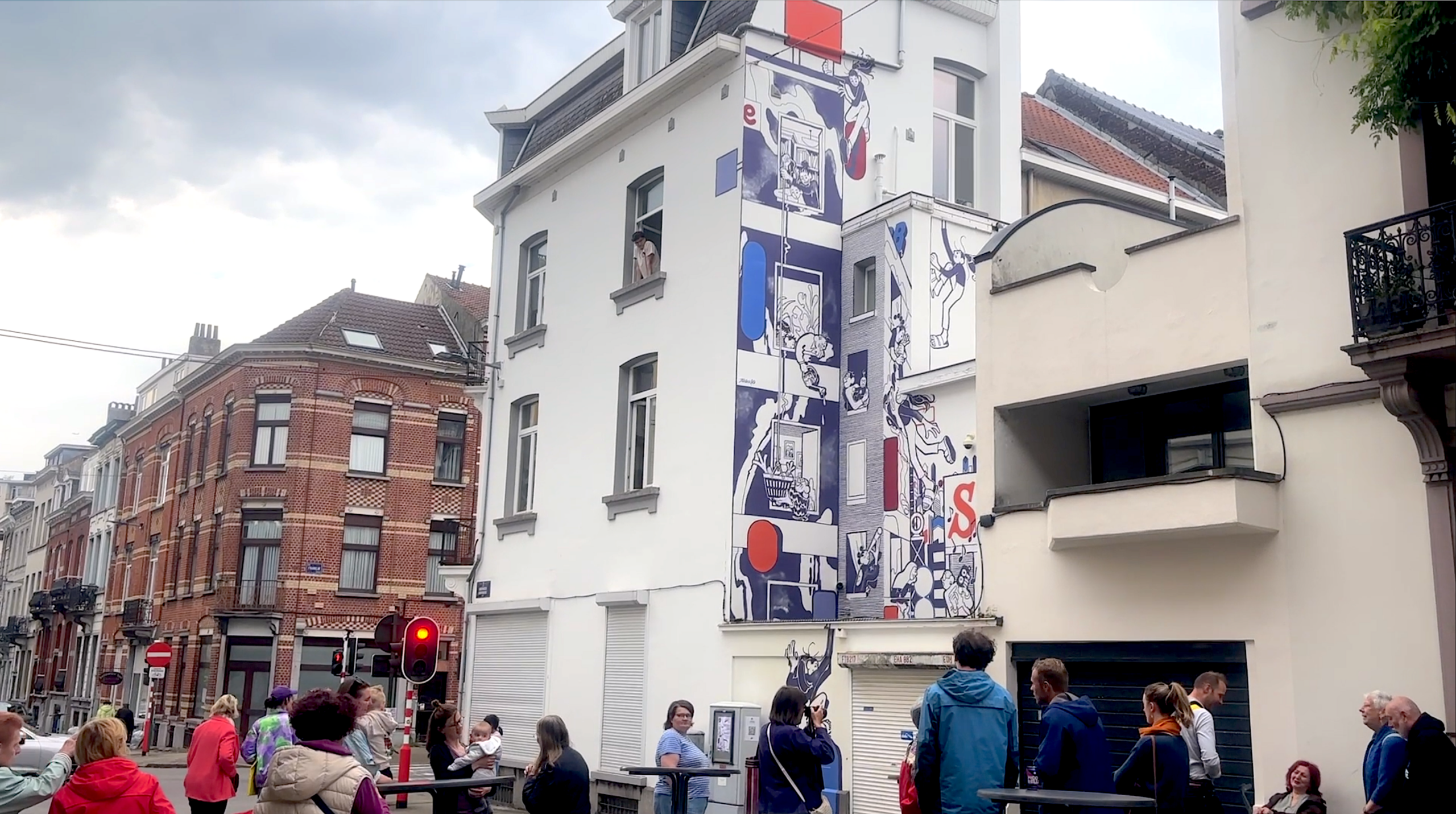 Fresque murale immobilier : fresque monumentale sur la façade d'un immeuble, rue Franklin à Bruxelles, avec des passants rassemblés devant
